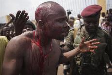 An opposition UDPS member bleeds from a head wound after being beaten by security forces in Kinshasa